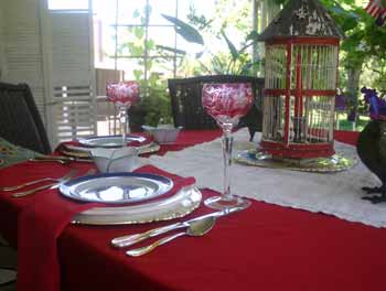 Red cut glass goblets and two-toned flatware finish the setting.