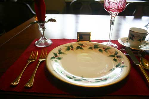 Gold flatware, a glass candle holder with a gold leaf candle ring